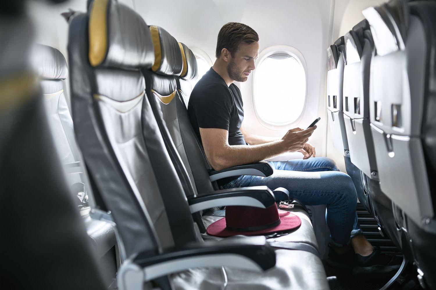 Ein Mann sitzt in einem Flugzeug und sieht aus dem Fenster