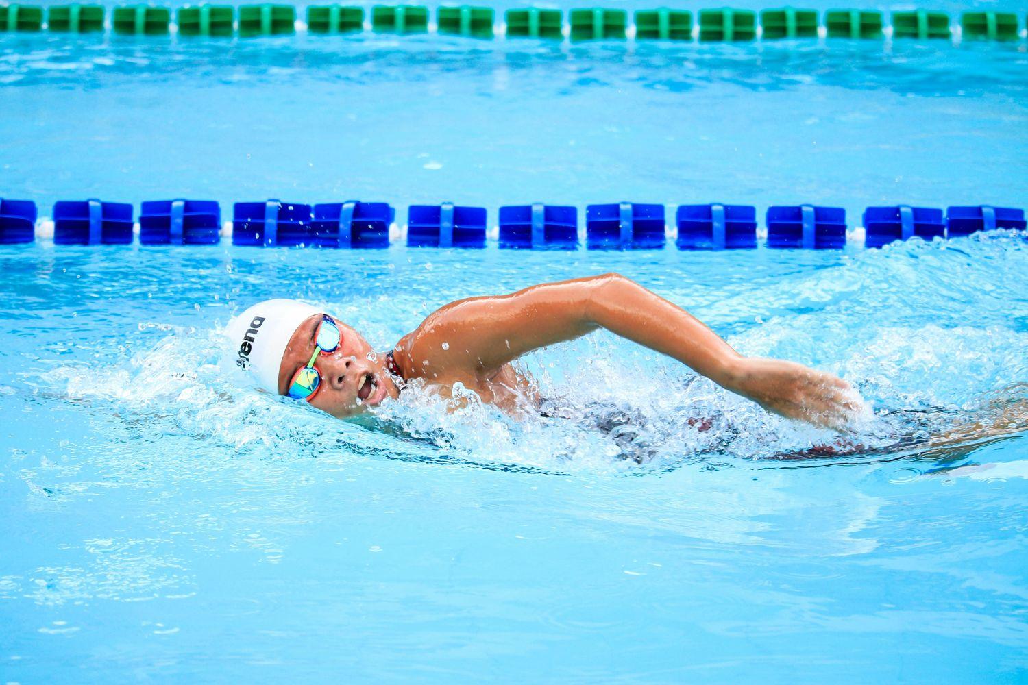 Person, die mit Schwimmkappe und Schwimmbrille in Pool krault